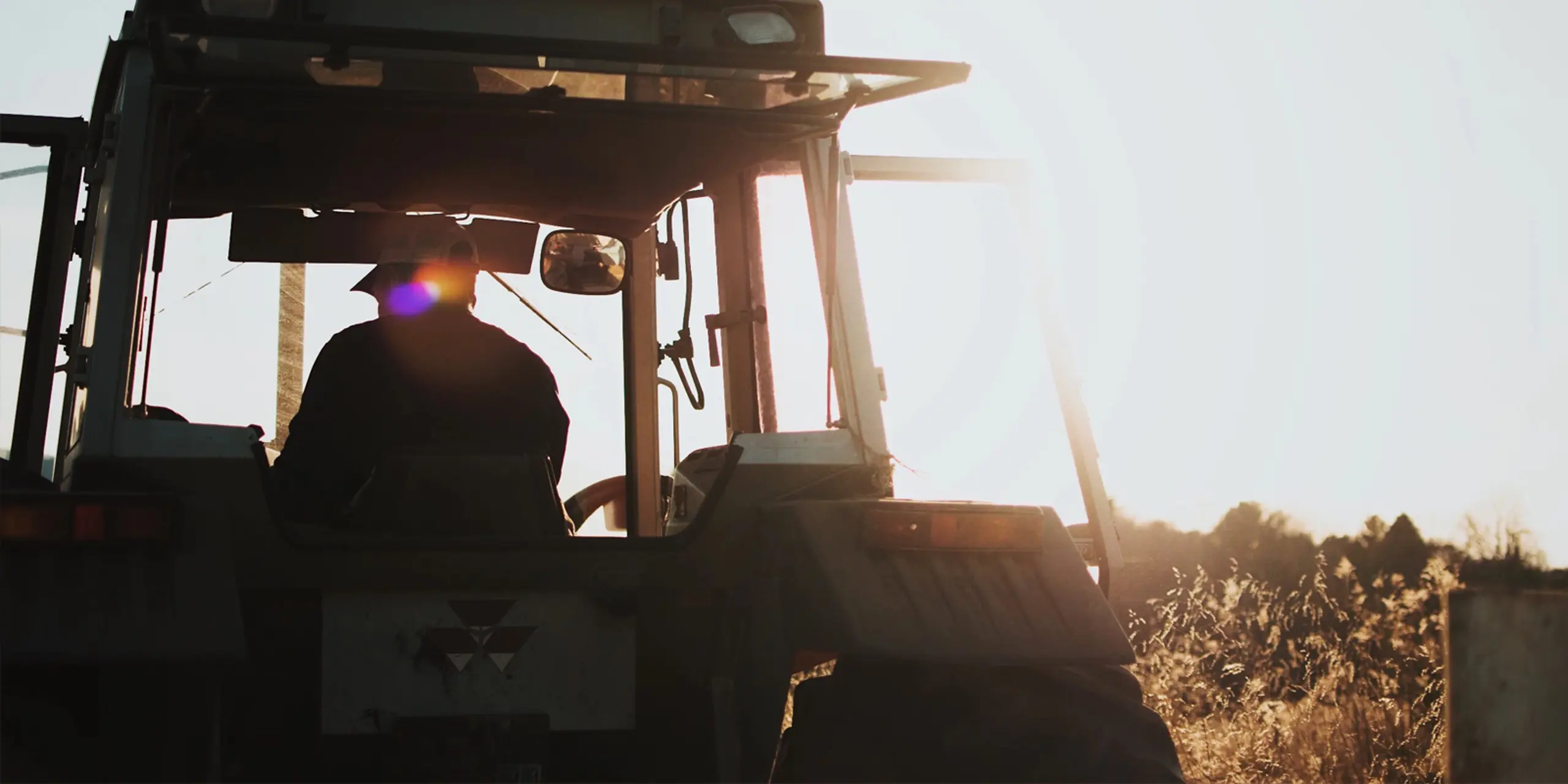 Man in a tractor in backlight